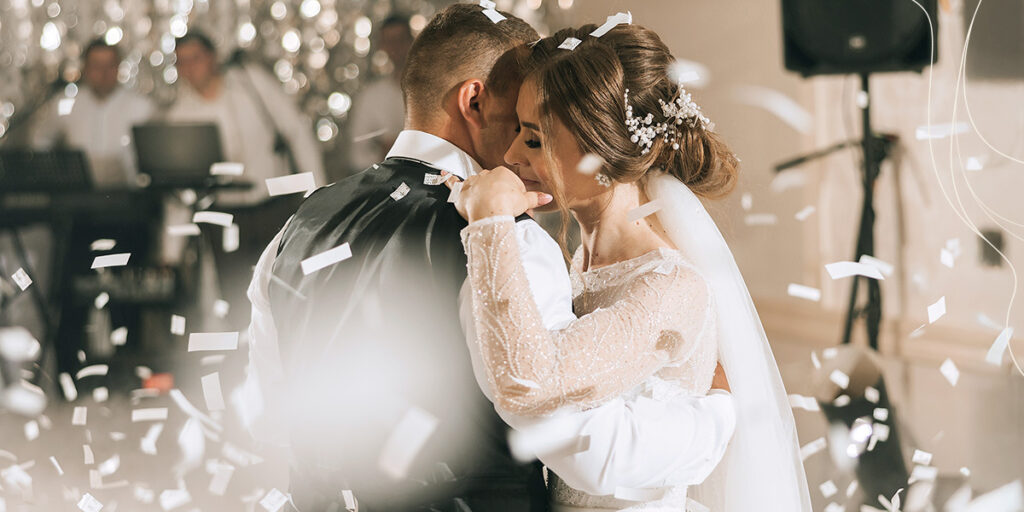 married man and woman at their wedding dancing with confetti