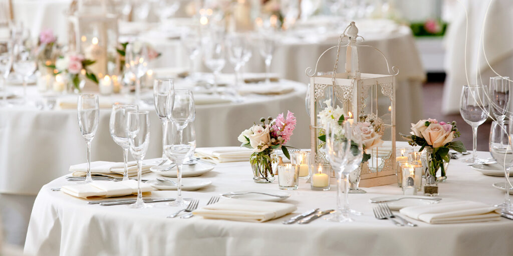 wedding dinner tables with pink flowers and white plates