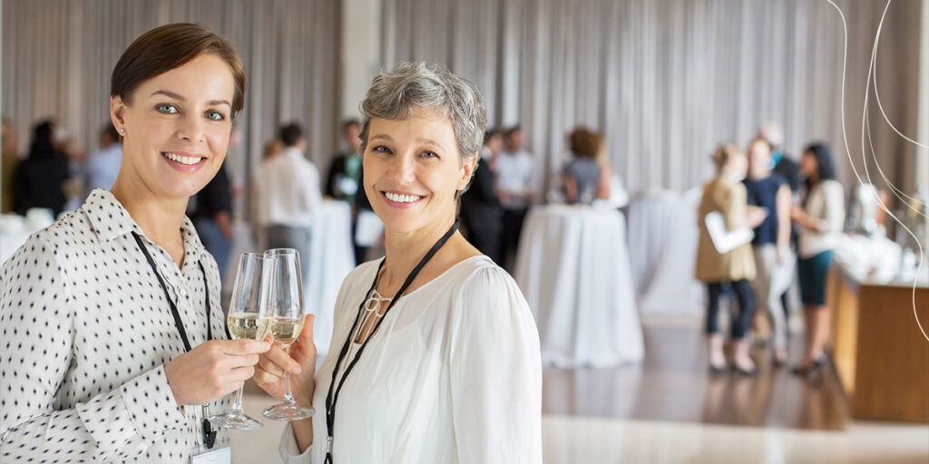 women cheering at corporate event holding champagne flutes