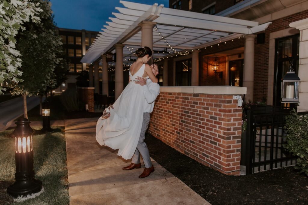 man and woman recently married spinning outside by a brick patio