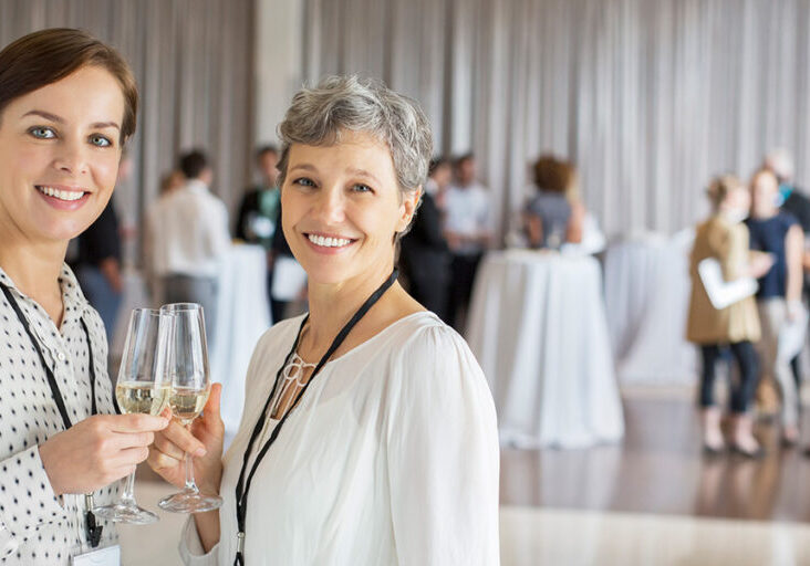 women cheering at corporate event holding champagne flutes