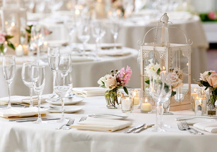 wedding dinner tables with pink flowers and white plates